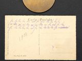 an old postcard with a coin, postcard, and other items on a table