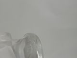 a clear glass vase with a curved top on a table