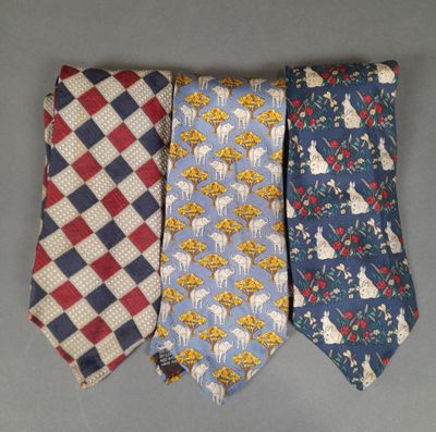 three different colored neck ties on a gray surface