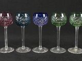 six different colored wine glasses lined up in a row