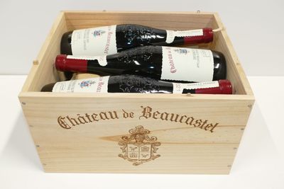 three bottles of wine in a wooden box on a table