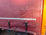 a red truck with a red tarp on the back of it