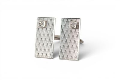 pair of silver cufflinks with diamonds on them on a white background