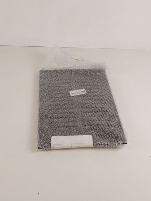 une image représentant une serviette grise posée sur une surface blanche