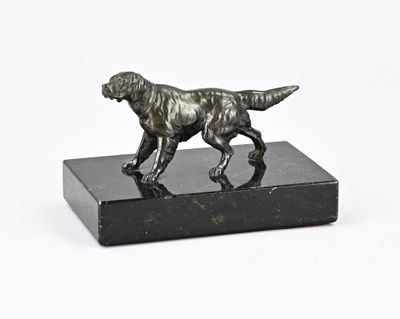 une statue de chien posée sur un bloc de marbre