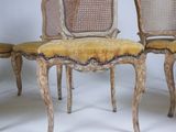 three chairs with a yellow upholstered seat and a cane back