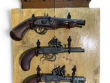 une plaque en bois sur laquelle sont représentées plusieurs armes anciennes