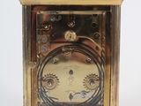 a gold clock that is sitting on a white surface