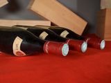 several bottles of wine are lined up on a red table