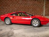 a red sports car parked in front of a brick wall