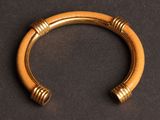 a close up of a gold bracelet on a black surface