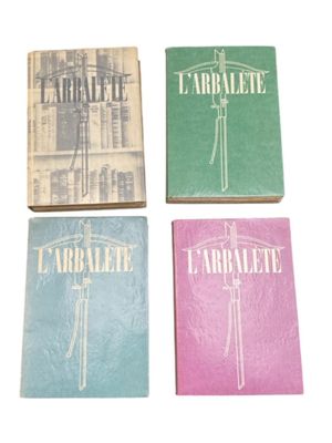 four books of different colors and designs on a white surface