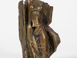 une statue en bronze d'une femme assise sur un rocher