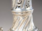 two silver vases with designs on them on a table