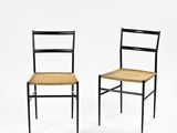 une paire de chaises noires avec des assises en osier sur fond blanc
