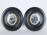 une paire de portraits, encadrés en noir et or, représentant un homme et une femme