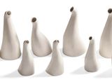 de nombreux vases blancs posés sur une surface blanche