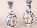 two blue and white vases with designs on them sitting side by side