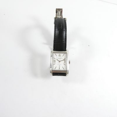 une montre posée sur une surface blanche