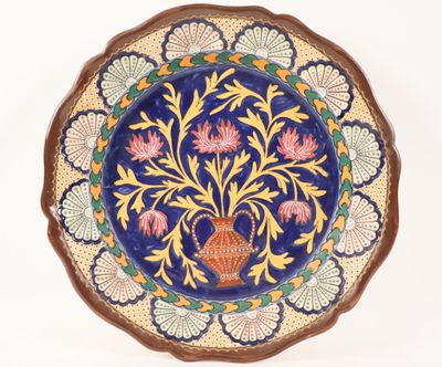 a decorative plate with a vase on it on a white background