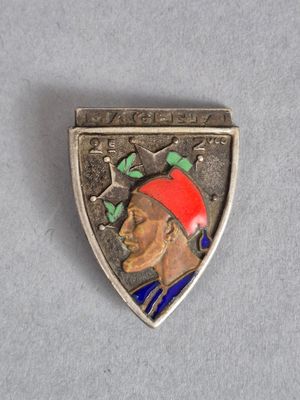 un gros plan sur un insigne métallique représentant un homme coiffé d'un chapeau rouge