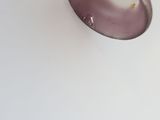 a purple vase sitting on top of a white table
