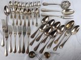 de nombreuses cuillères et fourchettes disposées sur une table