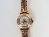 an image of a gold watch with a white face on a white surface