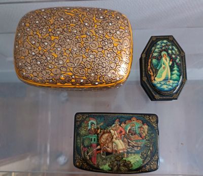 three small boxes that are sitting on a shelf