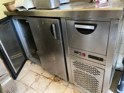 a stainless steel counter top with a freezer in the corner