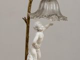 a lamp that has a statue on it on a table