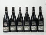 six bouteilles de vin sont alignées sur une table