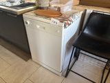 a black chair sitting next to a white dishwasher in a kitchen