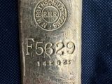 un lingot d'argent posé sur un tissu bleu