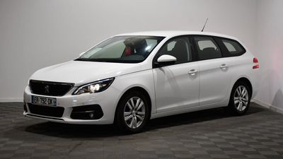the small white car is parked in a room with a checkered floor
