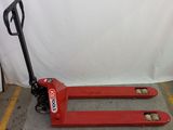 a red fork lifter sitting on the floor in a warehouse