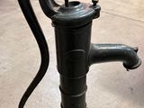 une pompe à eau à l'ancienne posée par terre dans une pièce