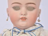 a close up of a doll wearing a white dress and a blue bow tie