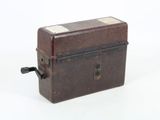 a small brown box with a black handle on a white surface