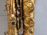 the saxophone is shiny gold and has a white background