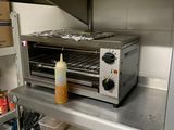 un four grille-pain posé sur une étagère dans une cuisine