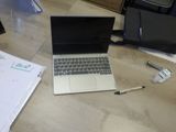 un ordinateur portable posé sur un bureau, à côté d'un sac