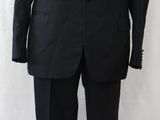 a black suit on a mannequin stand against a white backdrop