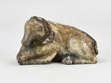 statue of an elephant laying down on a white surface