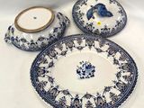 trois assiettes bleues et blanches et un bol posés sur une table blanche