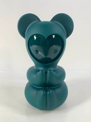 un petit ours bleu avec un cœur sur la tête