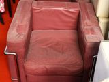 a red chair that is in a room with a red carpet