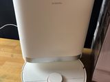 an image of a white air purifier sitting on top of a wooden table