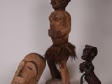 deux sculptures en bois représentant un homme et une femme sur fond blanc