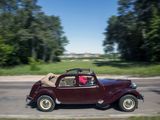 a red car driving down the road with a dog in the back seat